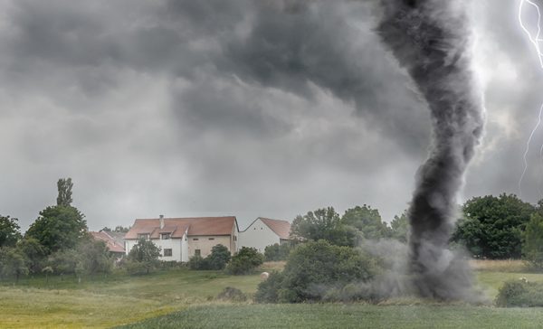Black tornado funnel and lightning over field during thunderstorm